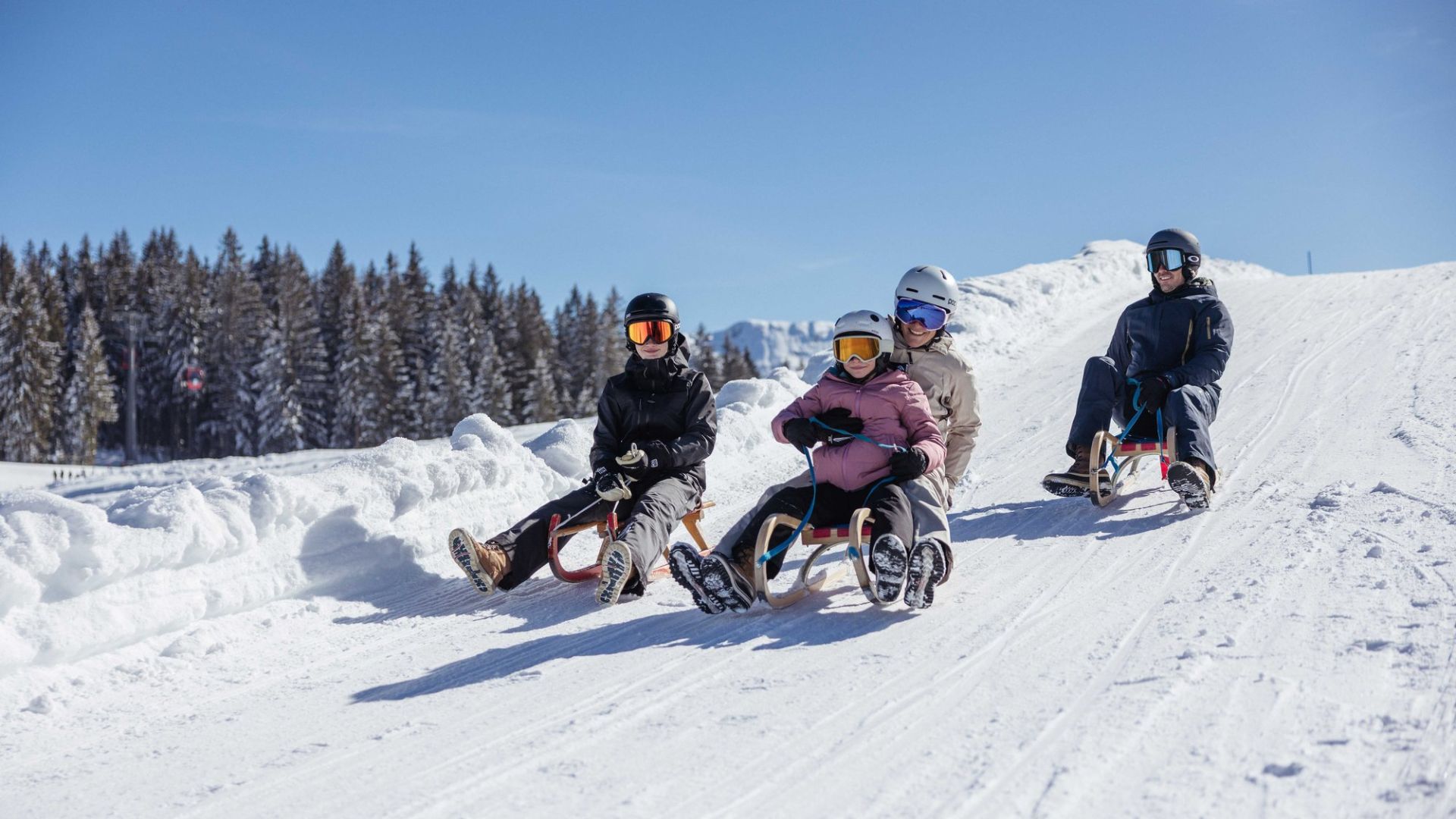 Familie beim Rodeln auf der Naturrodelbahn im Alpbachtal